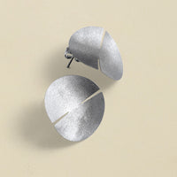 Close-up of a sleek, sterling silver earring with a polished finish