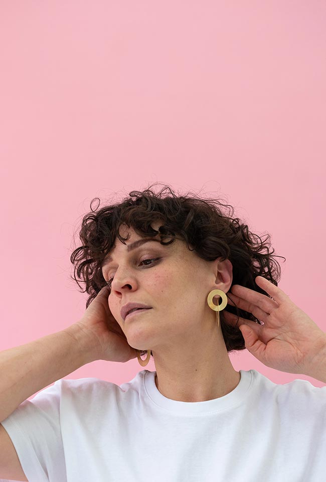 Close-up of a woman with beautiful curly hair wearing Gold Coated Handmade Bronze Earrings