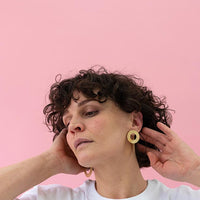 Close-up of a woman with beautiful curly hair wearing Gold Coated Handmade Bronze Earrings
