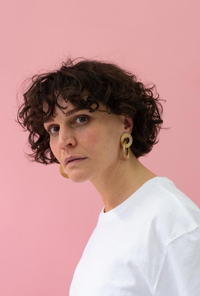 Close-up of a woman with beautiful curly hair wearing Gold Coated Handmade Bronze Earrings