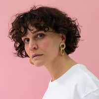 Close-up of a woman with beautiful curly hair wearing Gold Coated Handmade Bronze Earrings