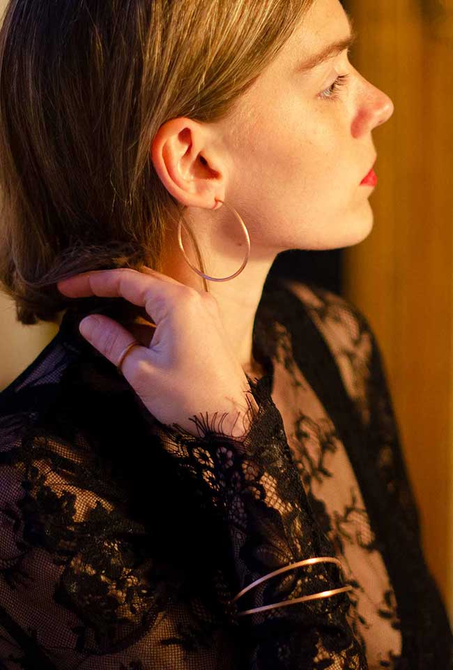 Bronze-colored handmade bangle worn by a stylish woman