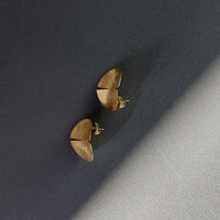 Close-up of a sleek, gold covered sterling silver earring with a polished finish