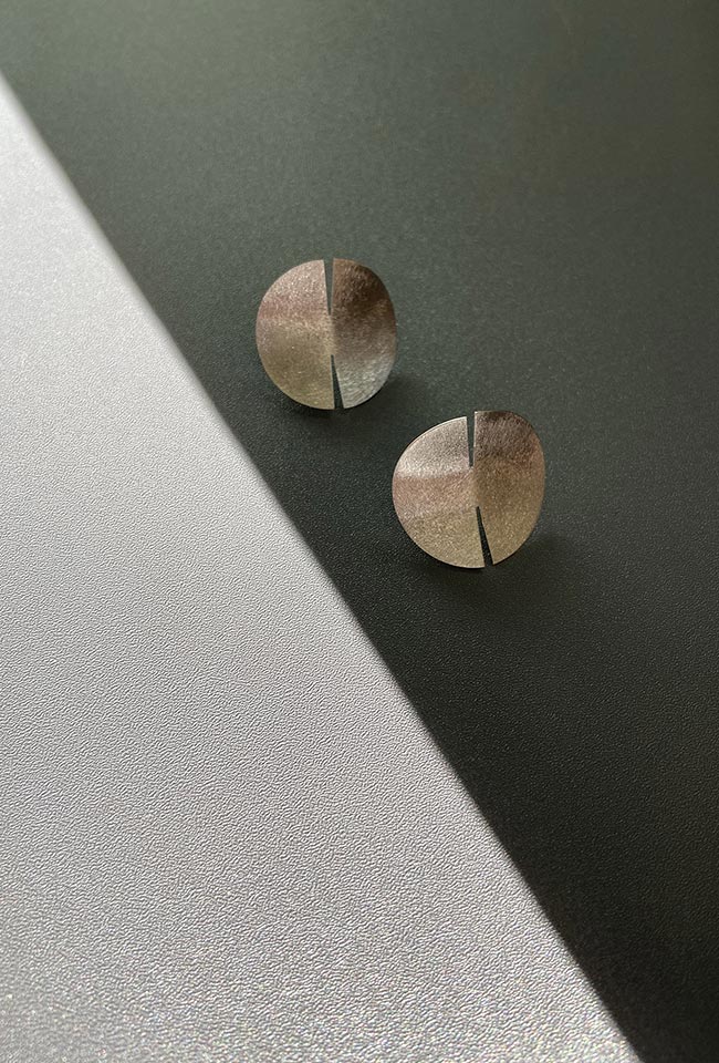 Close-up of a sleek, sterling silver earring with a polished finish