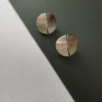 Close-up of a sleek, sterling silver earring with a polished finish