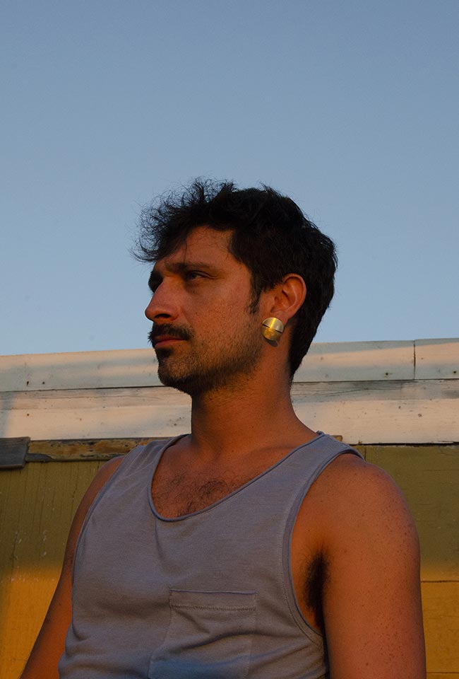 Close-up of a men's ear adorned with a stunning gold covered sterling silver earring