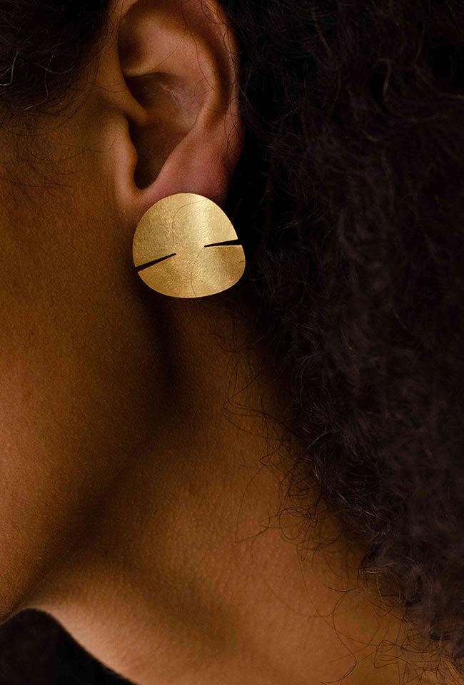 Close-up of a woman's ear adorned with a stunning sterling gold covered silver earring