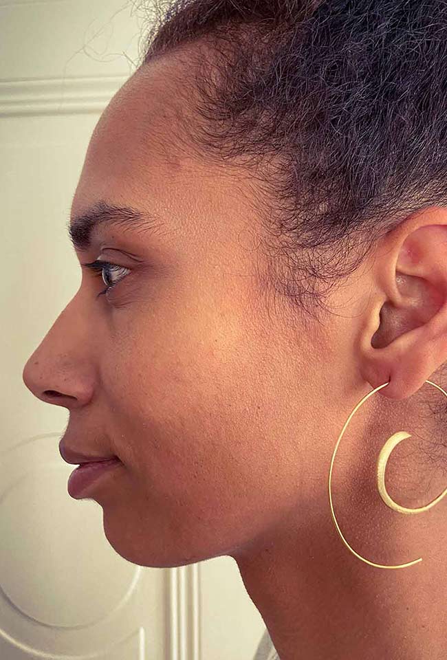 Close-up of Gold-Coated Handmade Silver Creoles adorning a woman's ear