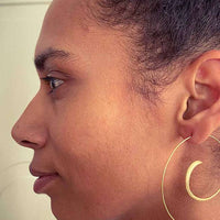 Close-up of Gold-Coated Handmade Silver Creoles adorning a woman's ear