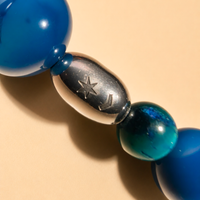 SCATTO RAVVICINATO DELLA: Collana Blue Beads di RIMA, Questa collana è composta da splendide perline in pietra naturale e dall'iconica perlina incisa con il marchio RIMA.