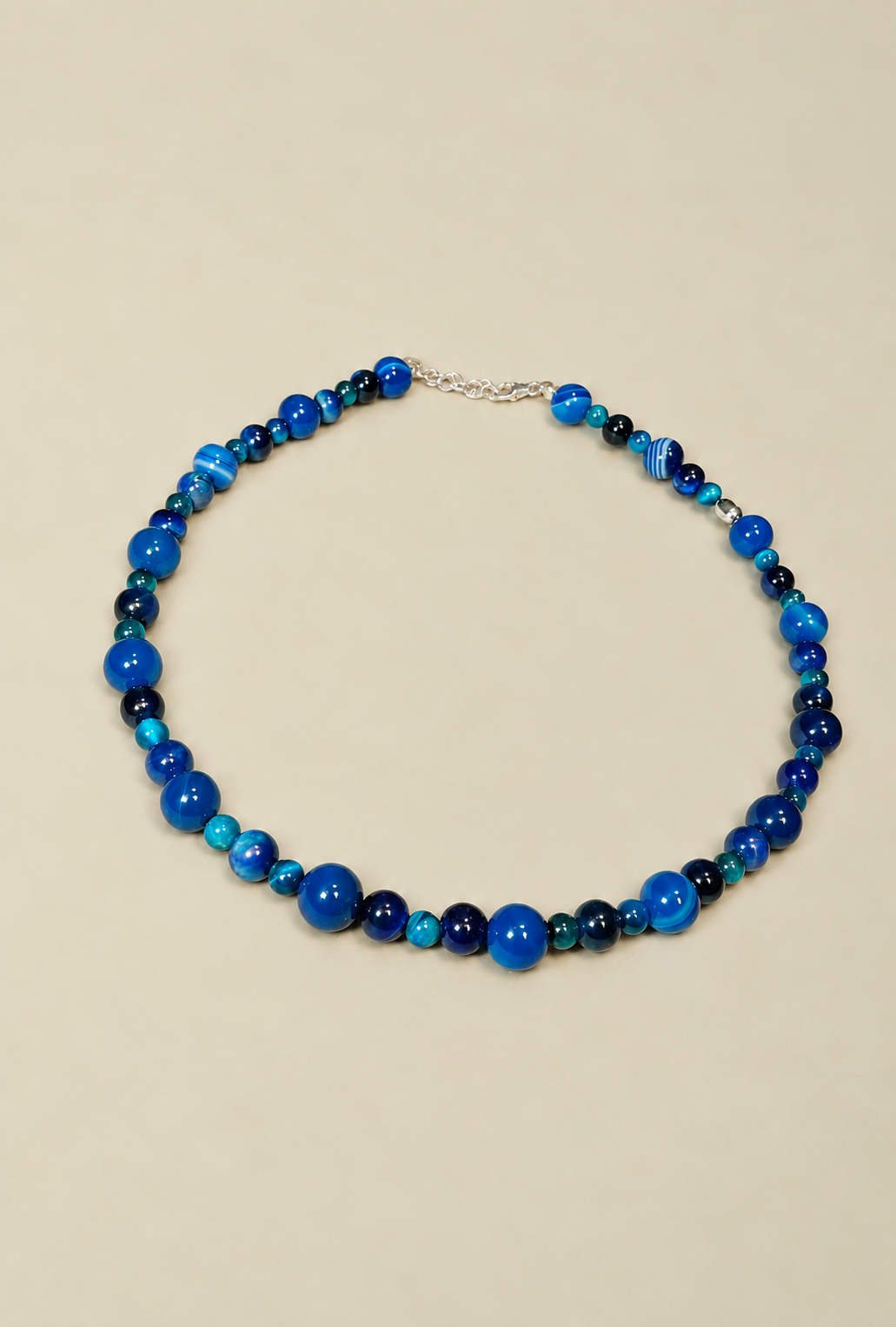 Collana Blue Beads di RIMA, Questa collana è composta da splendide perline in pietra naturale dalle tonalità variabili del blu, estremamente lucide e impreziosite da venature e sfumature più scure. 