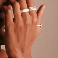 la modella indossa al polso: Bracciale Bordeaux Beads di RIMA: Questo bracciale è composto da splendide e piccolissime perline in pietra naturale dalle tonalità bordeaux, impreziosite dall'alternanza di perline dorate ancora più minute. 