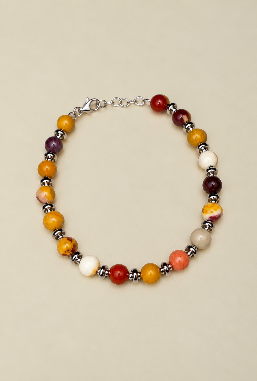 Bracciale Red-Yellow Beads di RIMA:  è composto da splendide perline in pietra naturale dalle tonalità variabili dal rosso al giallo, impreziosite da sfumature e venature che vanno dall'avorio al violaceo. Il design è rifinito da ulteriori perline argentate e lucenti, disposte in modo da suddividere finemente le varie pietre.