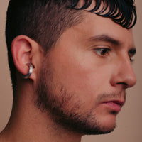 close up of a man wearing a silver coated cuff