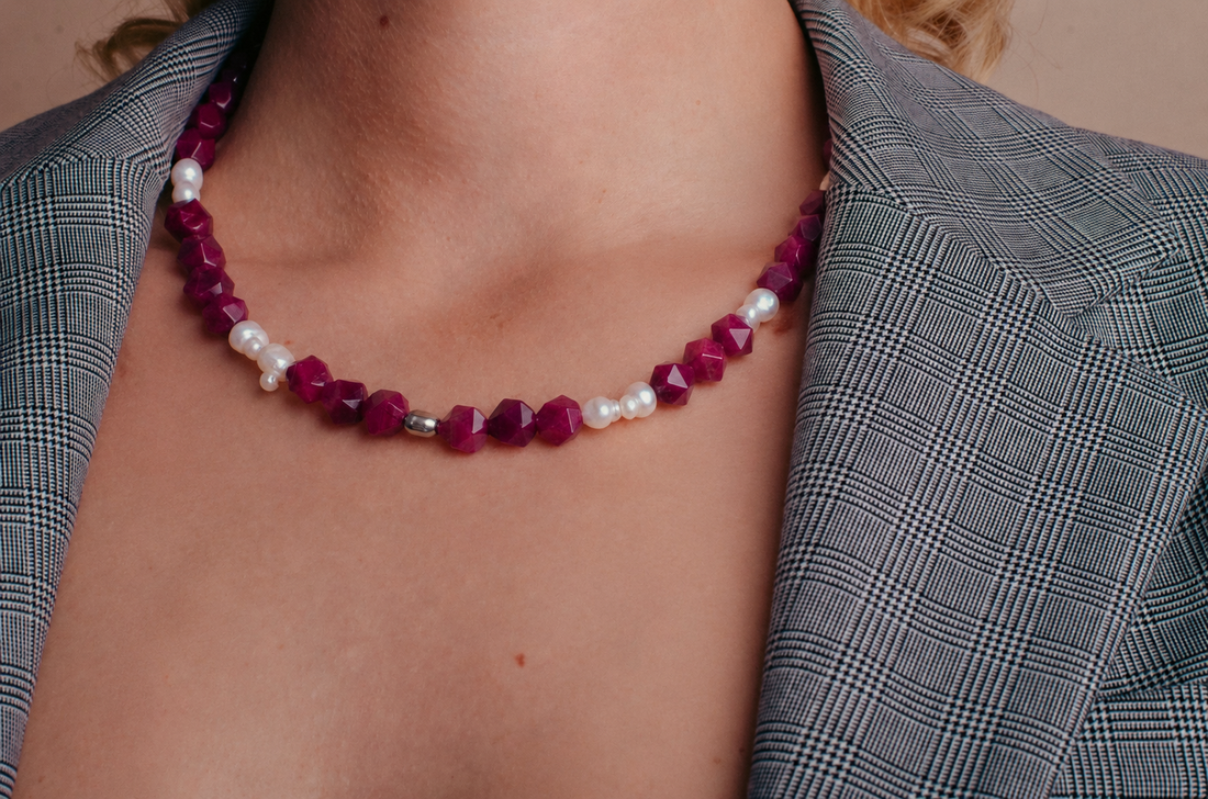 la modella indossa: Collana Pink &  Pearls di RIMA: perline di pietra rosa scuro, dalle forme squadrate e spigolose, e perle naturali dalle linee imperfette, tondeggianti 