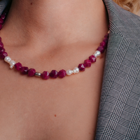 la modella indossa: Collana Pink &  Pearls di RIMA: perline di pietra rosa scuro, dalle forme squadrate e spigolose, e perle naturali dalle linee imperfette, tondeggianti 