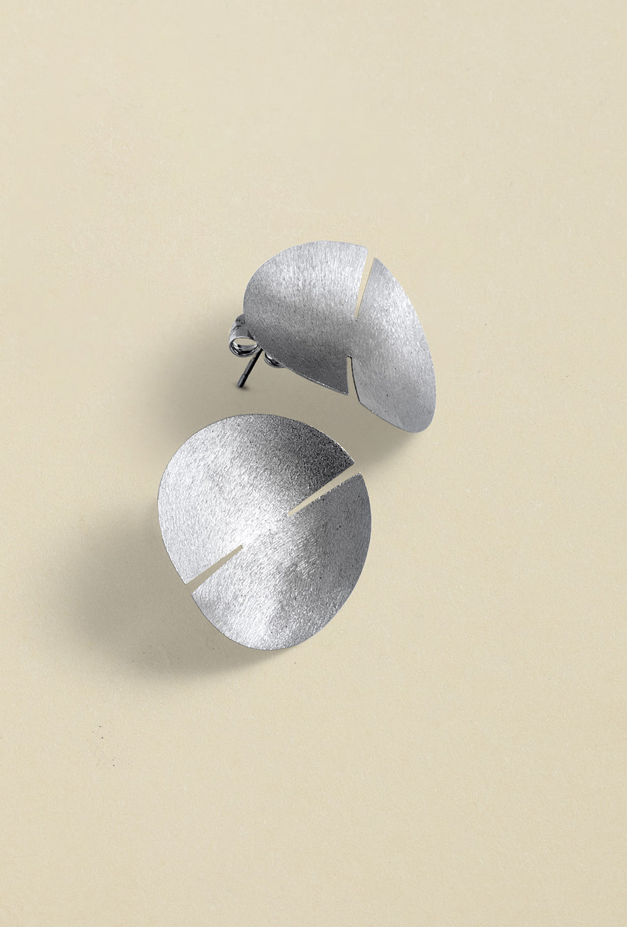 Close-up of a sleek, sterling silver earring with a polished finish