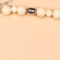 scatto ravvicinato della Collana White Beads di RIMA:

-splendide pietre dalle tonalità avorio panna, impreziosite da venature
-iconica perlina incisa con il marchio RIMA.
