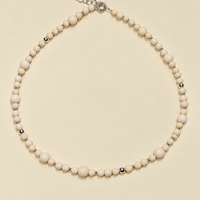 Collana White Beads smaller di RIMA:
 collana con  protagonista una splendida pietra dalle tonalità avorio panna, impreziosita da venature che le donano grande naturalezza.