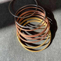 Piled up bangles together, showcasing a variety of colors and textures for a modern layered look