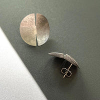 Close-up of a sleek, sterling silver earring with a polished finish