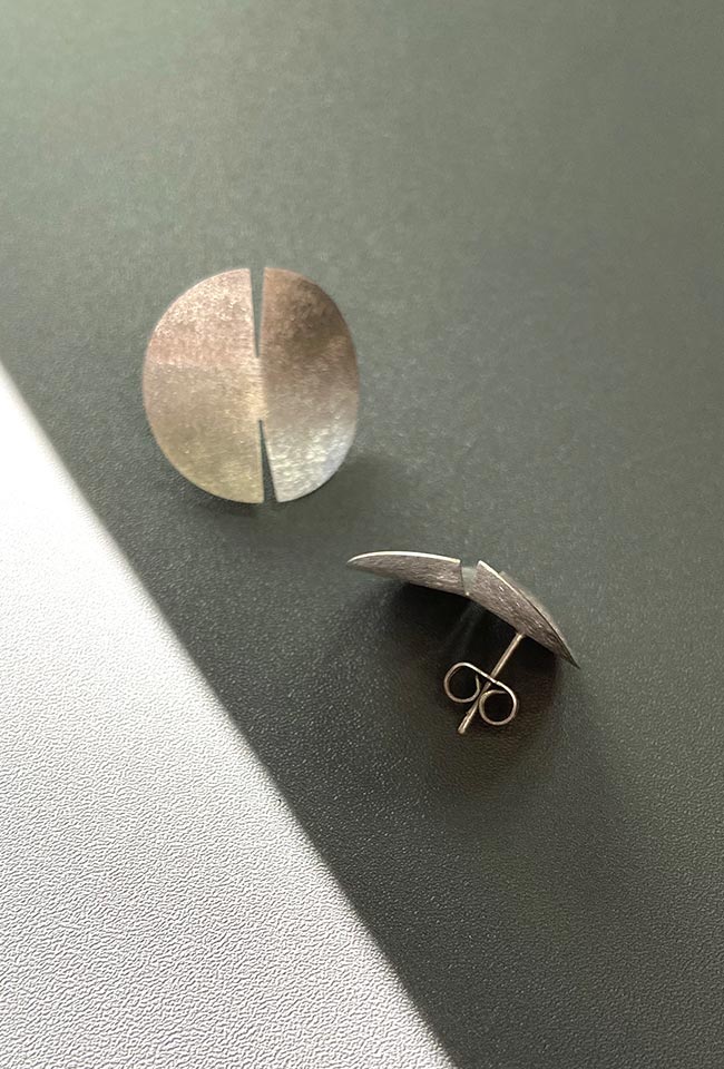 Close-up of a sleek, sterling silver earring with a polished finish
